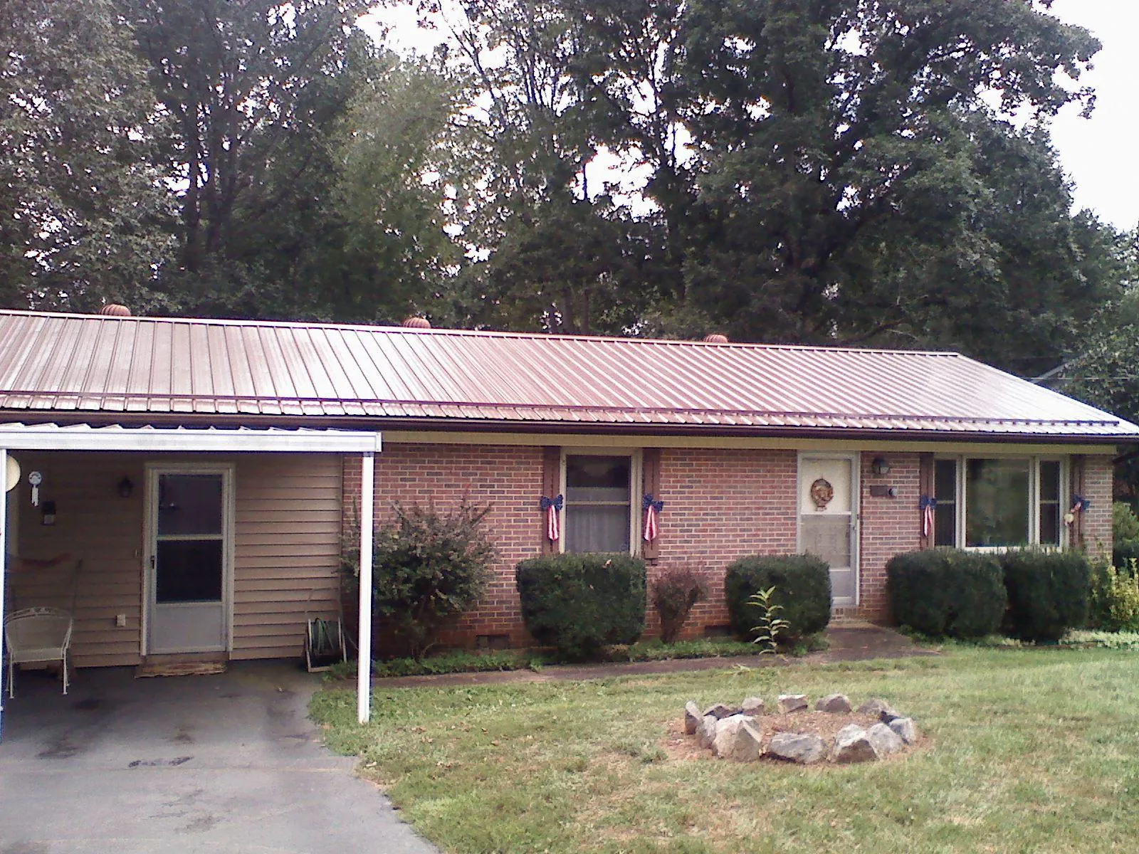 Bronze metal roof and carport on a brick ranch home — Roof Repair work by our crew in Mc Donough