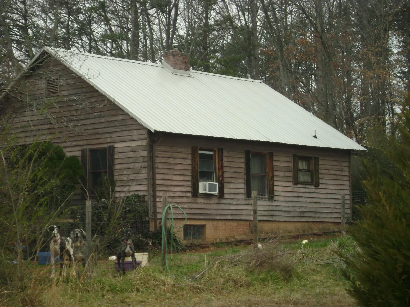 White metal roof on an old wood sided farmhouse, from a Metal Roof Installation job in Mc Donough